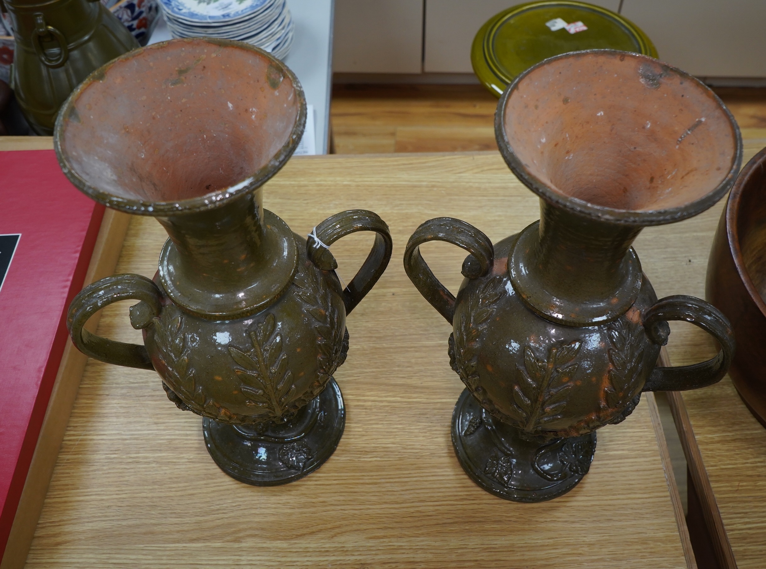 A pair of 19th century continental green glazed two handled pottery vases, 43cm high. Condition - fair